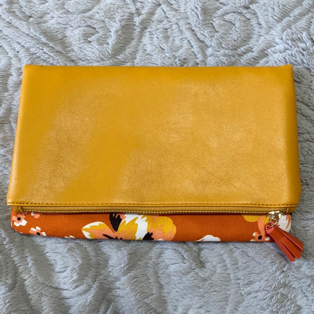 Leather and canvas folded clutch. Top zip with tassel. New, never used.